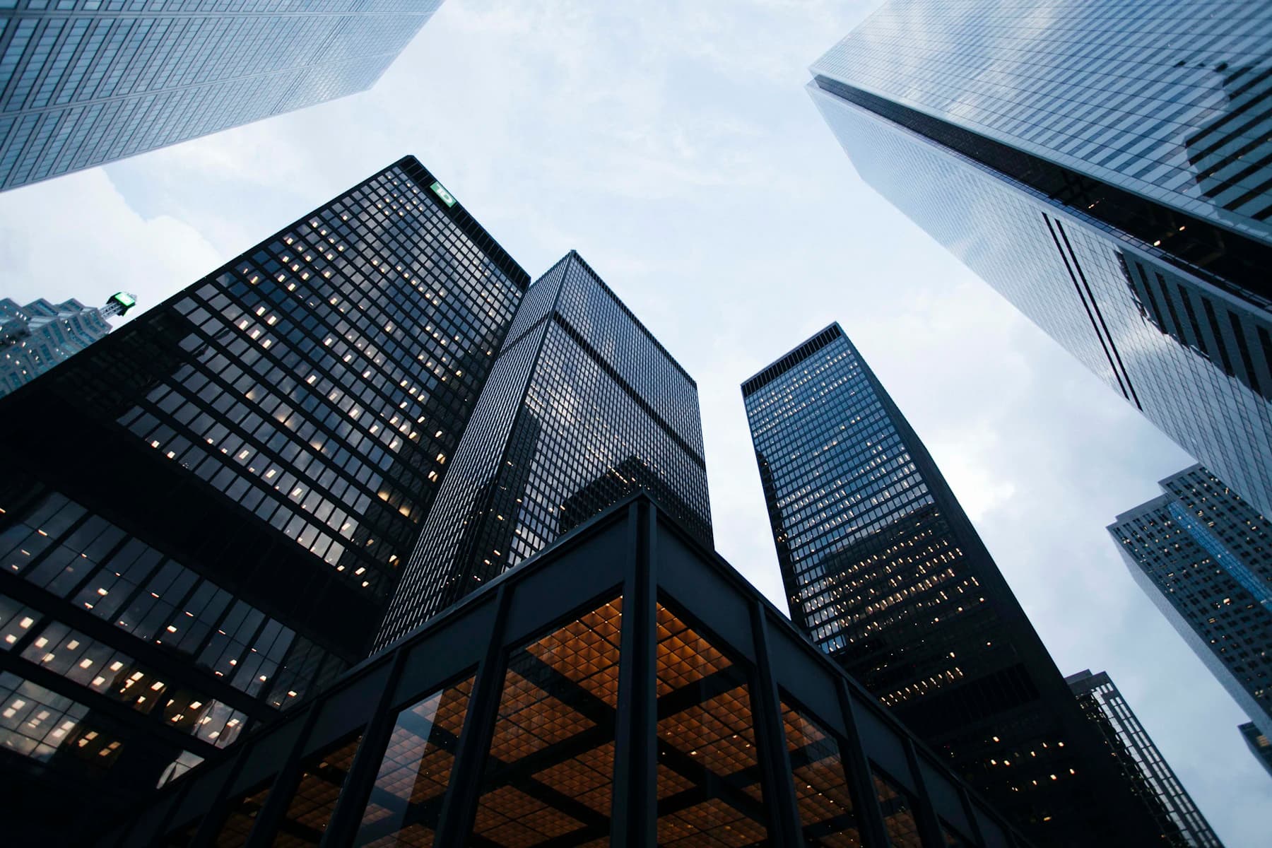 Glass skyscrapers photographed from below against an open sky