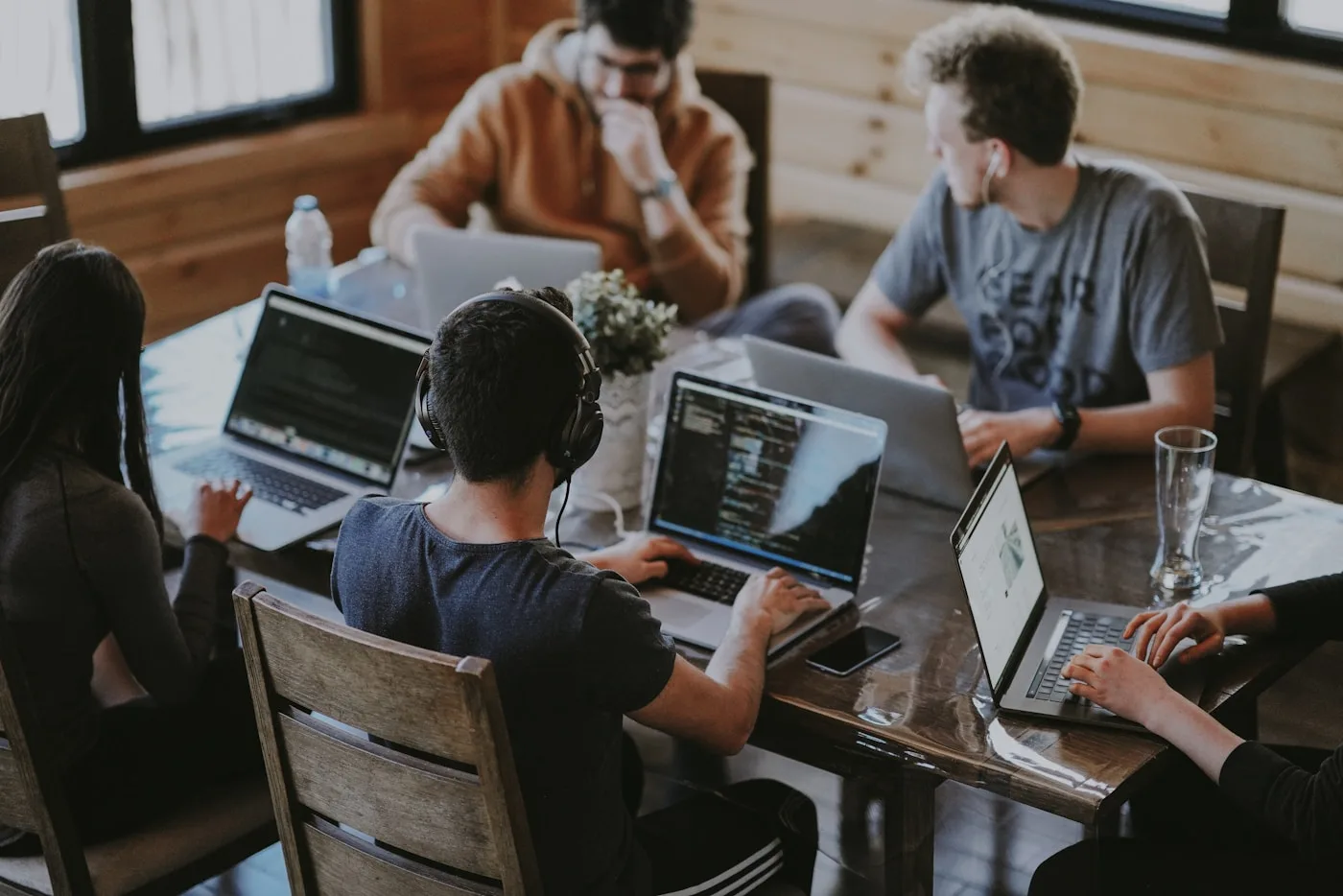A team exchanging ideas around laptops at a shared table