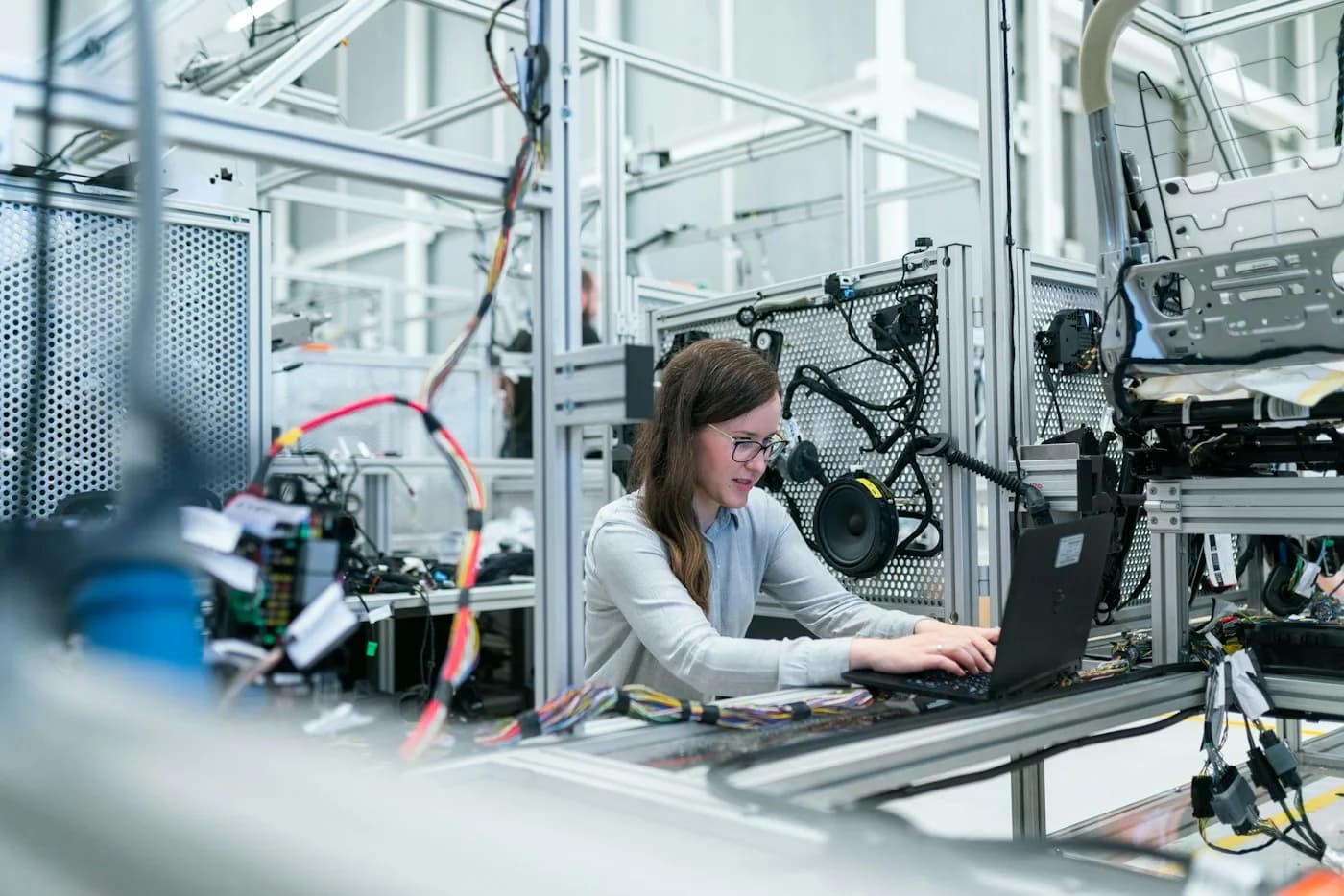 An engineer using a laptop beside electronic test equipment in a laboratory
