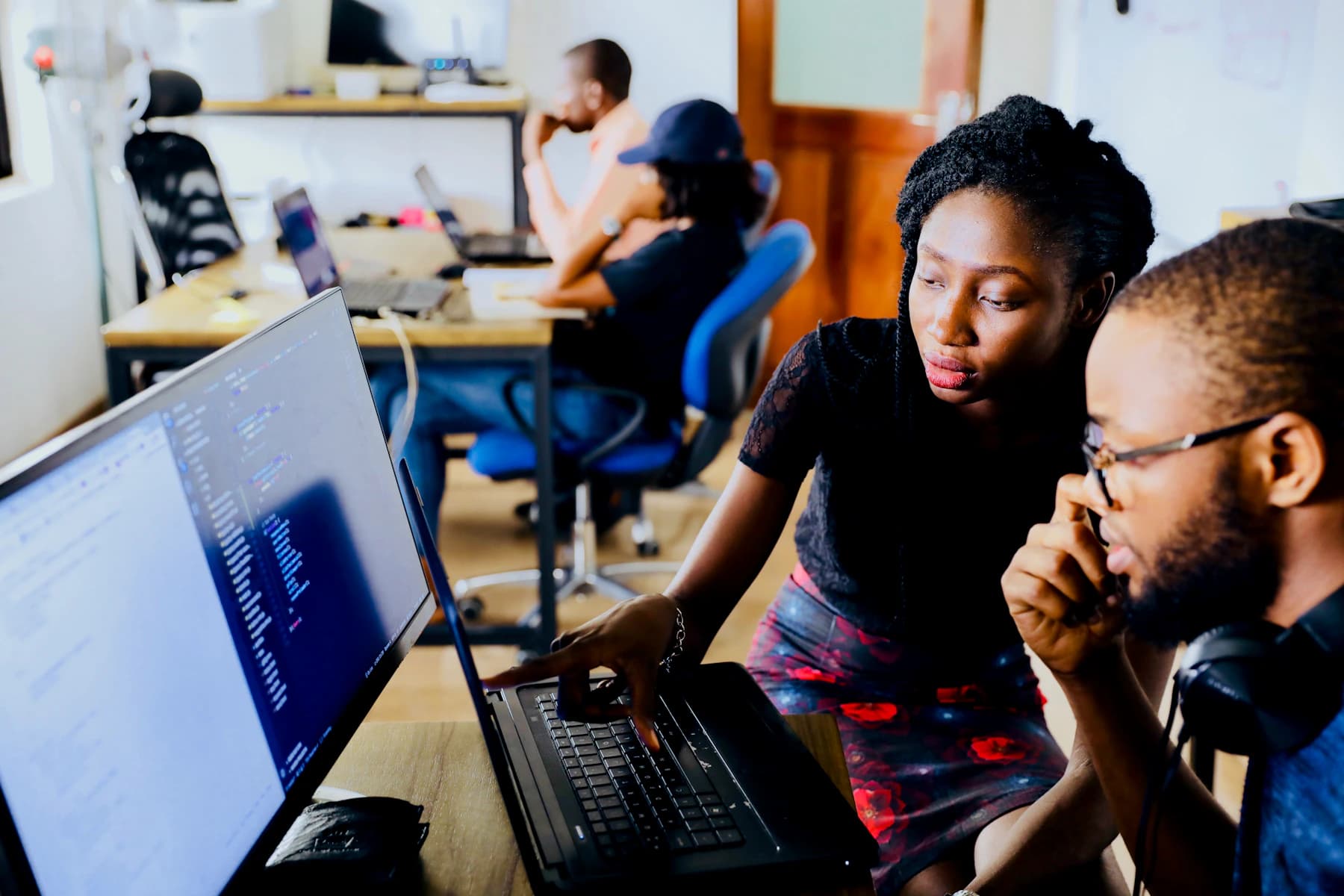Two technology professionals collaborating at a computer during a workshop